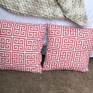 2 pink and white decorative pillows